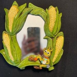 Chalkware mirror surrounded by corn cobs with a cute little bug in the corner.
